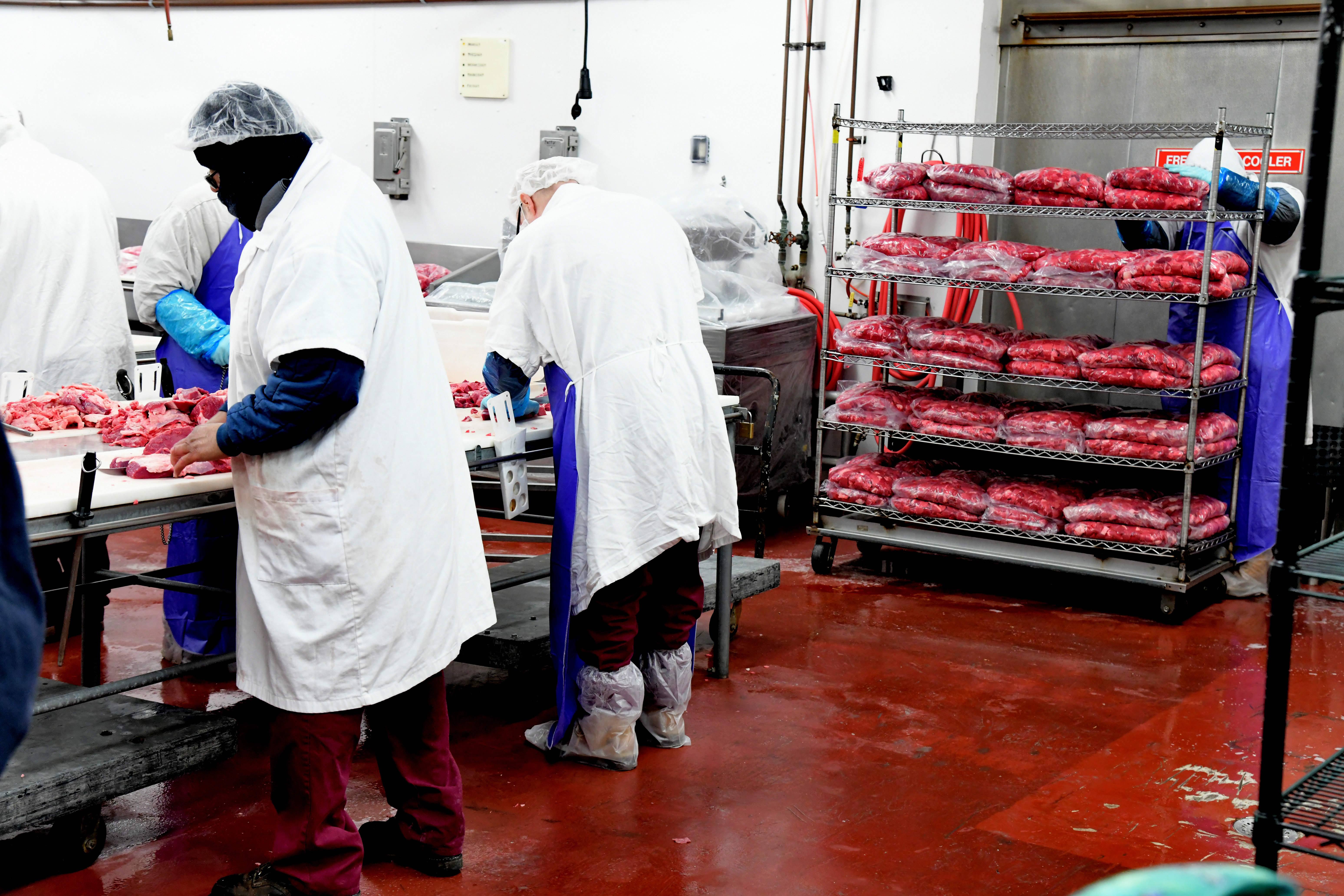 men cutting meat in facility men cutting meat in facility